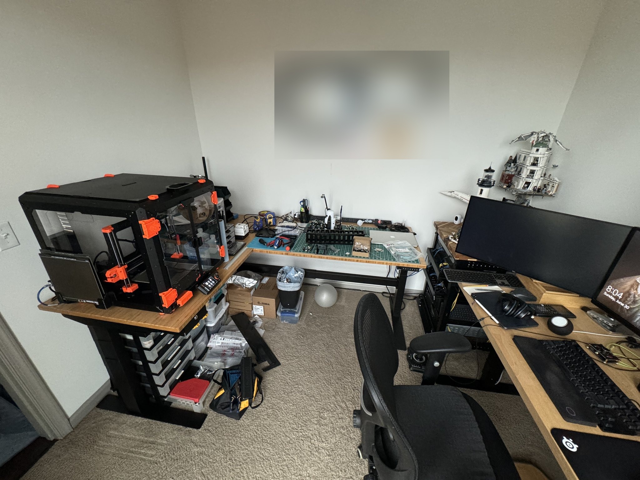 The printer, workbench, and desk together in the office.