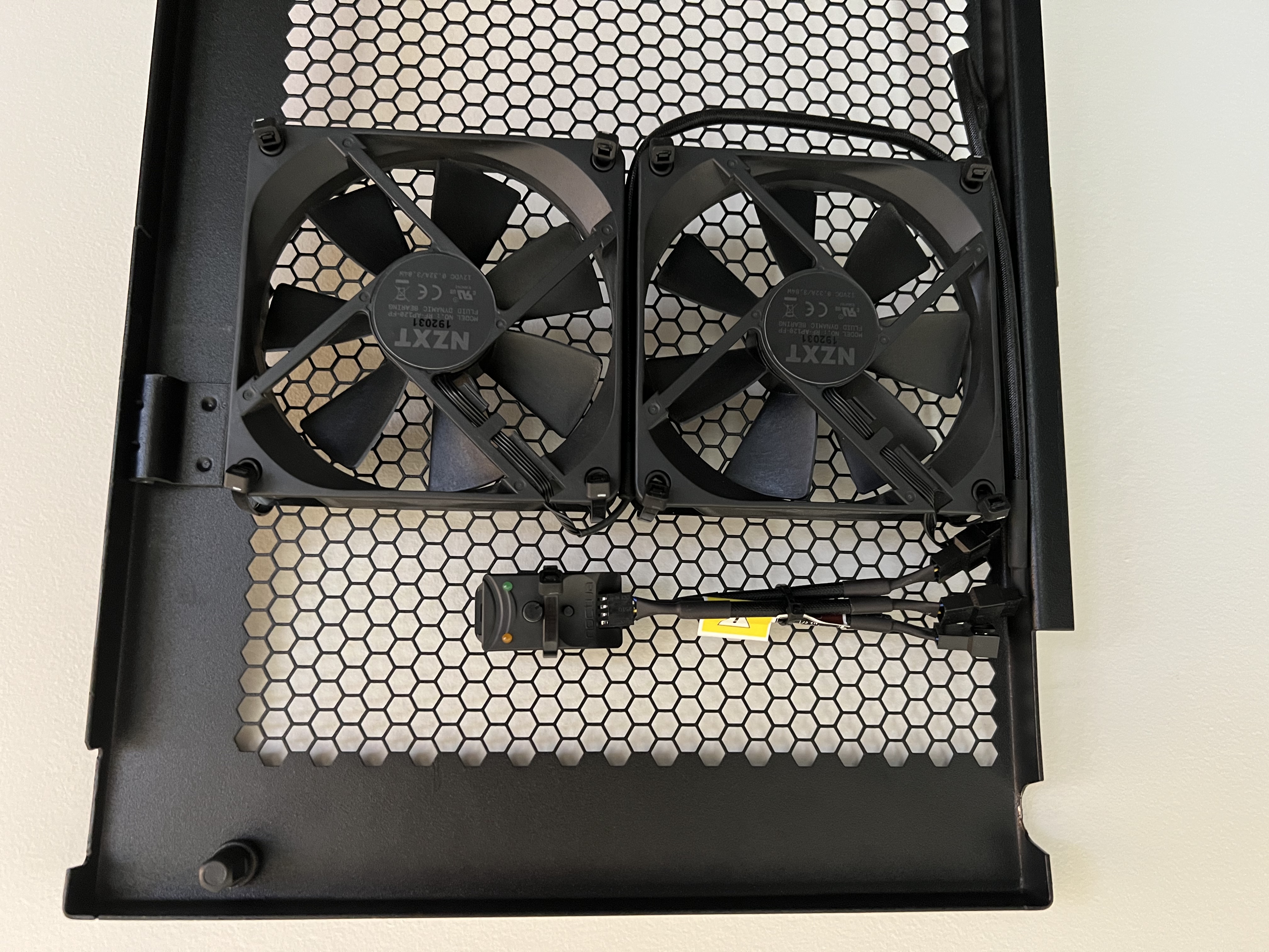 Two NZXT fans and a Noctua fan controller zip-tied to the rack door