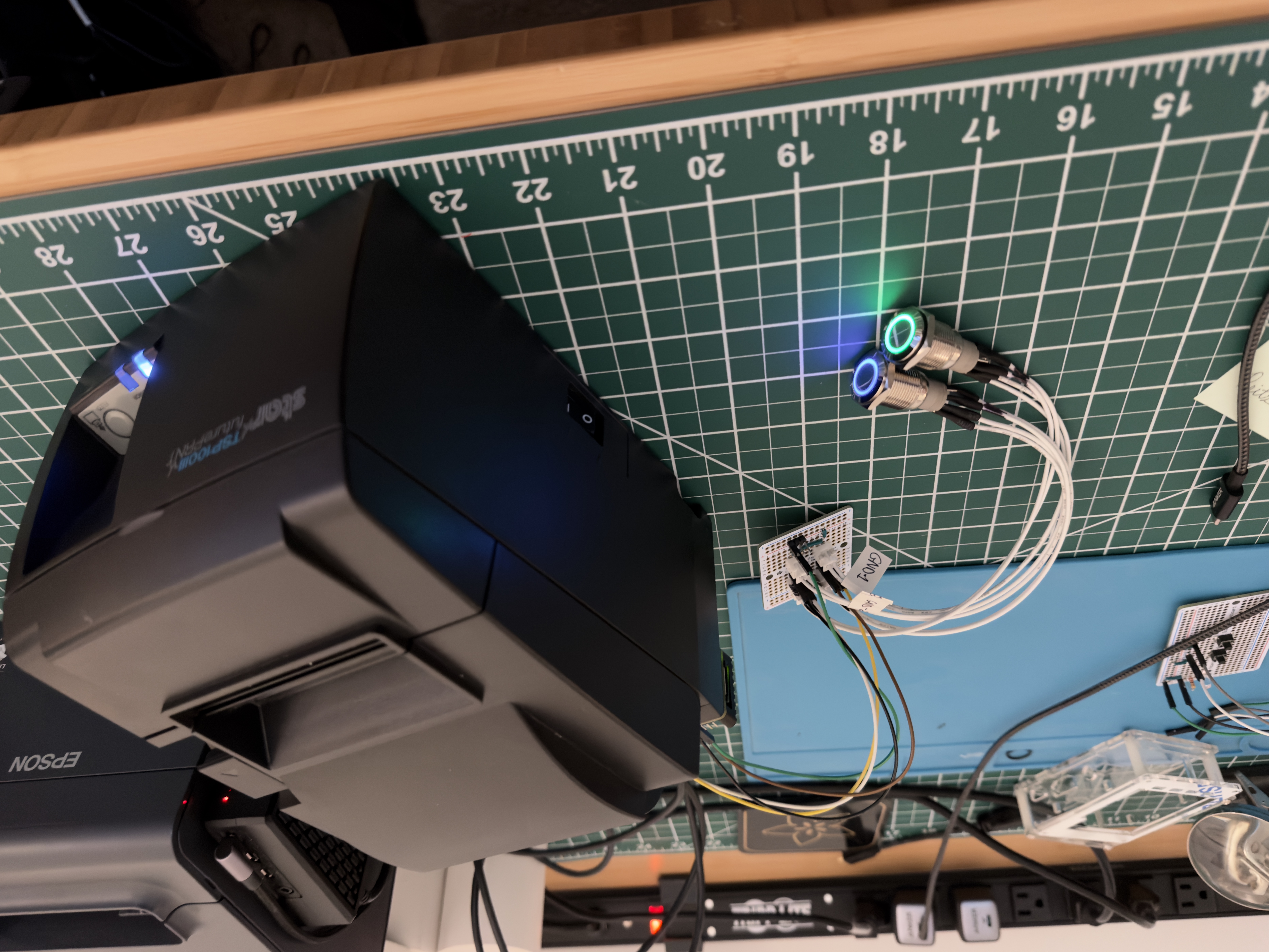 Receipt printer with two illuminated metal buttons connected to a small prototyping board